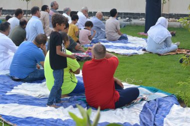 Kahire, Mısır, 9 Temmuz 2022: Bir çocuk, cami yakınlarındaki açık hava sahasında yapılan Kurban Bayramı ibadetleri ve kutlamalarının daha büyük olduğu İslam bayramı kutlamalarında tatlı dağıtıyor
