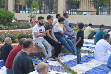 Kahire, Mısır, 9 Temmuz 2022: Bir çocuk, cami yakınlarındaki açık hava sahasında yapılan Kurban Bayramı ibadetleri ve kutlamalarının daha büyük olduğu İslam bayramı kutlamalarında tatlı dağıtıyor