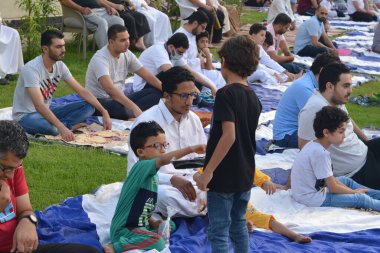 Kahire, Mısır, 9 Temmuz 2022: Bir çocuk, cami yakınlarındaki açık hava sahasında yapılan Kurban Bayramı ibadetleri ve kutlamalarının daha büyük olduğu İslam bayramı kutlamalarında tatlı dağıtıyor