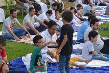 Kahire, Mısır, 9 Temmuz 2022: Bir çocuk, cami yakınlarındaki açık hava sahasında yapılan Kurban Bayramı ibadetleri ve kutlamalarının daha büyük olduğu İslam bayramı kutlamalarında tatlı dağıtıyor