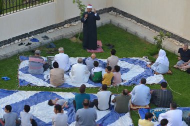 Kahire, Mısır, 9 Temmuz 2022: Cami vaizi İmam, cami yakınlarındaki açık bir hava sahasında Kurban Bayramı namazı ve kutlamalarının olduğu bir tören düzenledi.