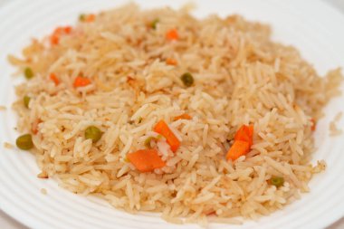 Bir tabak sıcak buğulanmış beyaz Basmati pilavı sebzeli bezelye ve dilimlenmiş soğanlı havuç, Çin mutfağı tarifi ve ayrıca doğulu Arapça ve Çin kökenli seçici bir odak noktası.