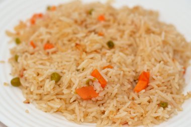 Bir tabak sıcak buğulanmış beyaz Basmati pilavı sebzeli bezelye ve dilimlenmiş soğanlı havuç, Çin mutfağı tarifi ve ayrıca doğulu Arapça ve Çin kökenli seçici bir odak noktası.