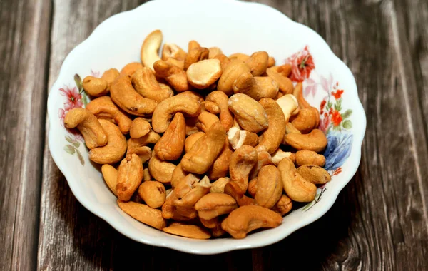 Plate Pile Peeled Roasted Salted Cashew Nuts Seeds Isolated Wooden — Fotografia de Stock