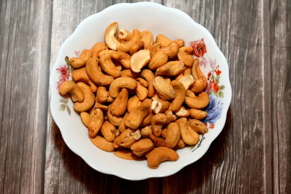 Plate Pile Peeled Roasted Salted Cashew Nuts Seeds Isolated Wooden — Fotografia de Stock