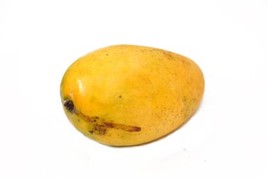 Beyaz zemin üzerinde izole edilmiş taze mango meyvesinin seçici odak noktası, tropikal ağaç Mangifera indikası tarafından üretilen ve boyut, şekil, tatlılık ve renk olarak değişen yenilebilir bir taş meyvedir.