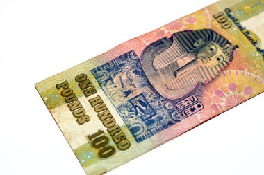 Eski 100 LEGP EGP 'nin ters tarafı 100 Mısırlı nakit para banknotu frizinin üstündeki Tutankamon maskesi dikey formatın merkezinde, seçici geri çekilen Mısır Sterlinlerinin odağı beyaz üzerine izole edilmiş.