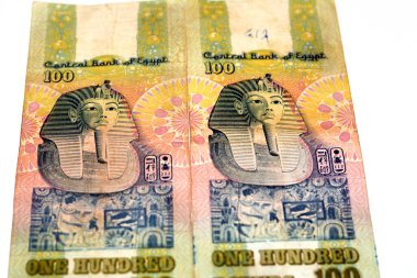Eski 100 LE EGP 'nin ters tarafları 100 Mısırlı nakit para banknotu frizin üstündeki Tutankamon maskesi dikey formatın merkezinde, seçici geri çekilen Mısır Sterlinleri beyaz üzerine izole