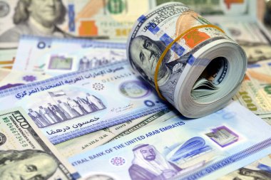 Yeni hatıra polimer. 50 Dirhem de Emirlik 'in şehitlerine anıtlı. 100 dolarlık Amerikan nakit para banknotları ve bir bantla birlikte Amerikan para rulosu.