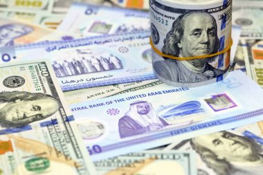 The new commemorative polymer 50 fifty Dirhams with Memorial to the martyrs of the Emirates UAE with USA American cash money banknotes of 100 $ one hundred dollars and a America money roll with a band