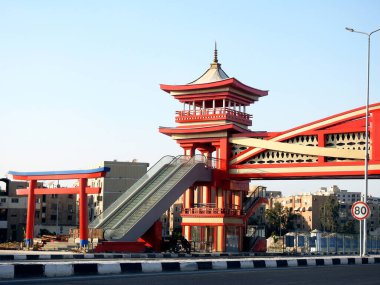 Kahire, Mısır, 31 Temmuz 2022: Shinzo Abe yeni devriye otoyolu Ekseni 'nde geleneksel Japon mimari tarzında tamamlanmış bir yaya köprüsü, elektrikli merdiven ve kırmızı renklerle servis edilir.