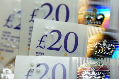 A closeup of Twenty pounds cash money bill Sterling polymer banknote from the bank of England that features the queen and J. M. W. Turner, selective focus of a macro shot of United Kingdom money