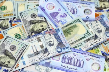 Pile of American dollar bills American cash money banknotes with Saudi Arabia riyals money banknotes and New Emirates polymer dirhams, American, Emirates, Saudi money exchange rates, selective focus