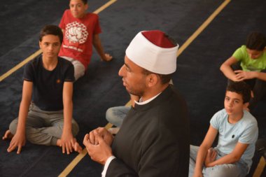 Cairo, Egypt, August 7 2022: A mosque preacher Imam performs a religious Khutbah (sermon) for young Muslim children inside a mosque during the summer Islamic educational program for kids in the mosque