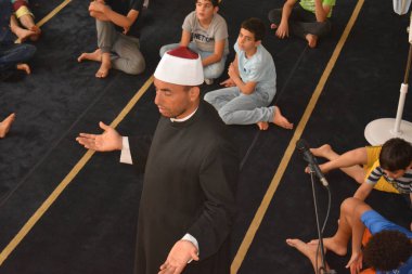 Cairo, Egypt, August 7 2022: A mosque preacher Imam performs a religious Khutbah (sermon) for young Muslim children inside a mosque during the summer Islamic educational program for kids in the mosque