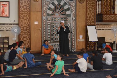 Cairo, Egypt, August 7 2022: A mosque preacher Imam performs a religious Khutbah (sermon) for young Muslim children inside a mosque during the summer Islamic educational program for kids in the mosque