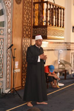 Cairo, Egypt, August 7 2022: A mosque preacher Imam performs a religious Khutbah (sermon) for young Muslim children inside a mosque during the summer Islamic educational program for kids in the mosque