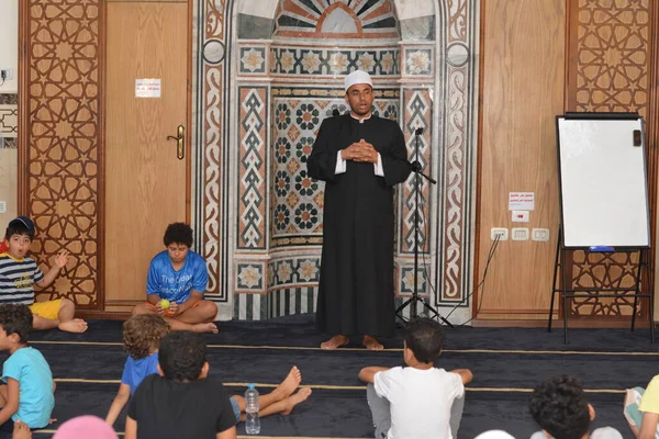 Cairo, Egypt, August 7 2022: A mosque preacher Imam performs a religious Khutbah (sermon) for young Muslim children inside a mosque during the summer Islamic educational program for kids in the mosque