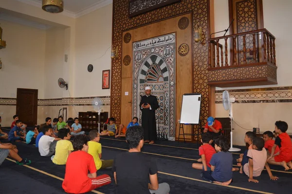 Cairo, Egypt, August 7 2022: A mosque preacher Imam performs a religious Khutbah (sermon) for young Muslim children inside a mosque during the summer Islamic educational program for kids in the mosque