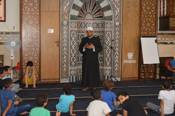 Cairo, Egypt, August 7 2022: A mosque preacher Imam performs a religious Khutbah (sermon) for young Muslim children inside a mosque during the summer Islamic educational program for kids in the mosque