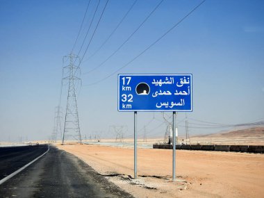 Suez, Egypt, August 12 2022: a road sign board in Suez Cairo highway in Arabic, Translation (Martyr Ahmed Hamdi Tunnel 17 KM, Suez 32 KM), Ahmed Hamdy tunnel is a car tunnel under the Suez canal