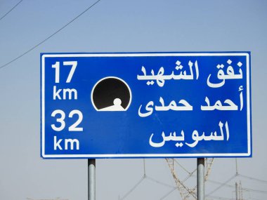 Suez, Egypt, August 12 2022: a road sign board in Suez Cairo highway in Arabic, Translation (Martyr Ahmed Hamdi Tunnel 17 KM, Suez 32 KM), Ahmed Hamdy tunnel is a car tunnel under the Suez canal
