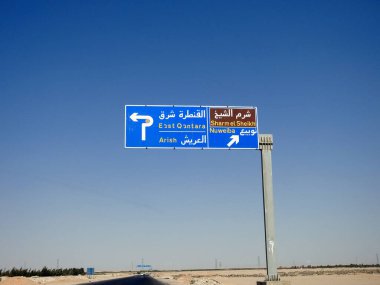South Sinai, Egypt, August 12 2022: a direction sign board in South Sinai gives directions of Sharm El Sheikh, East Qantara, Arish and Nuweiba cities in the highway written in Arabic and English