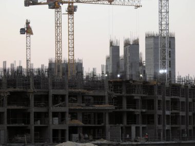 Giza, Egypt, August 20 2022: A construction site of a new high rise in Egypt new buildings under construction and skyscrapers with cranes, Egyptian new real estate developmental projects before sunset