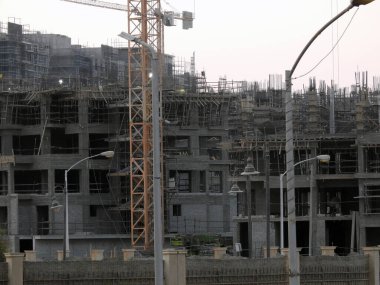 Giza, Egypt, August 20 2022: A construction site of a new high rise in Egypt new buildings under construction and skyscrapers with cranes, Egyptian new real estate developmental projects before sunset