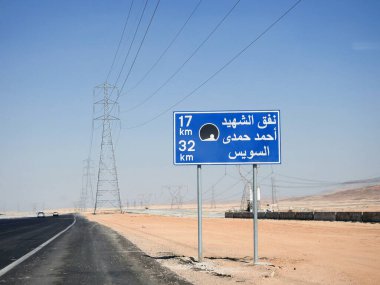 Suez, Egypt, August 12 2022: a road sign board in Suez Cairo highway in Arabic, Translation (Martyr Ahmed Hamdi Tunnel 17 KM, Suez 32 KM), Ahmed Hamdy tunnel is a car tunnel under the Suez canal