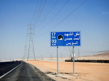 Suez, Egypt, August 12 2022: a road sign board in Suez Cairo highway in Arabic, Translation (Martyr Ahmed Hamdi Tunnel 17 KM, Suez 32 KM), Ahmed Hamdy tunnel is a car tunnel under the Suez canal
