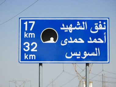 Suez, Egypt, August 12 2022: a road sign board in Suez Cairo highway in Arabic, Translation (Martyr Ahmed Hamdi Tunnel 17 KM, Suez 32 KM), Ahmed Hamdy tunnel is a car tunnel under the Suez canal