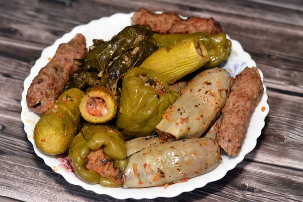 Stuffed squash zucchini Mahshi, eggplants, wrapped grape leaves, bell peppers filled with white rice, onion, parsley, dill and coriander and food beef  Kofta, kebab and tarb kofta which is minced meat