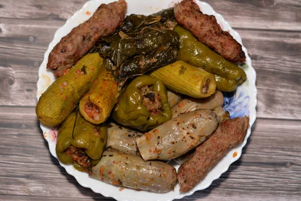 Stuffed squash zucchini Mahshi, eggplants, wrapped grape leaves, bell peppers filled with white rice, onion, parsley, dill and coriander and food beef  Kofta, kebab and tarb kofta which is minced meat