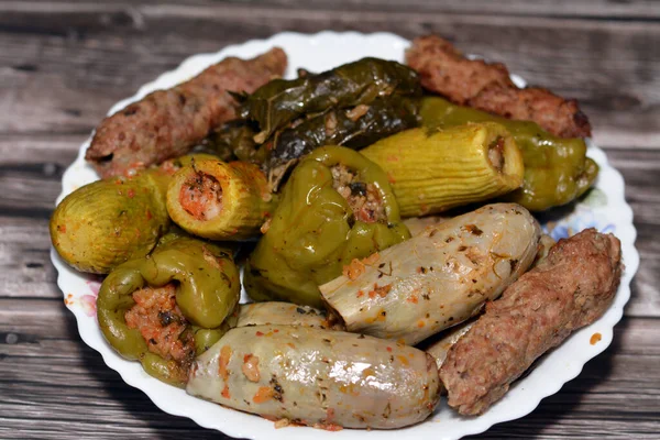 Stuffed squash zucchini Mahshi, eggplants, wrapped grape leaves, bell peppers filled with white rice, onion, parsley, dill and coriander and food beef  Kofta, kebab and tarb kofta which is minced meat
