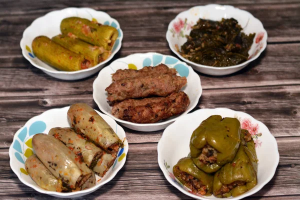 Stuffed squash zucchini Mahshi, eggplants, wrapped grape leaves, bell peppers filled with white rice, onion, parsley, dill and coriander and food beef  Kofta, kebab and tarb kofta which is minced meat