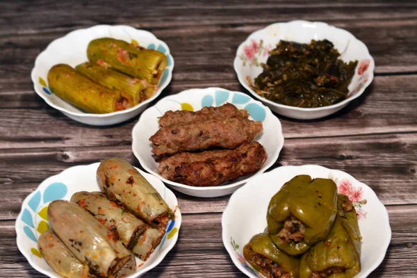 Stuffed squash zucchini Mahshi, eggplants, wrapped grape leaves, bell peppers filled with white rice, onion, parsley, dill and coriander and food beef  Kofta, kebab and tarb kofta which is minced meat