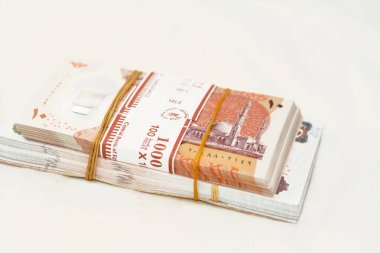 selective focus of stack of new Egyptian money banknotes currency of different values with rubber bands isolated on white background, pile of new polymer 10 LE and 50 EGP Egyptian pounds and 200 LE