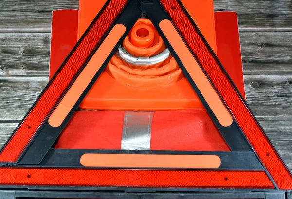 Car safety measures of warning foldaway reflective road hazard warning triangle, safety vest with reflective stripes, car traffic cone and phosphorescent reflective stickers, selective focus