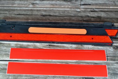 Bir uyarı katmanı yansıtıcı yol tehlike uyarı üçgeni ve tahtadan arka planda izole edilmiş bir çift fosforlu yansıtıcı çıkartma, ulaşım güvenliği ve yol onarımının seçici odak noktası