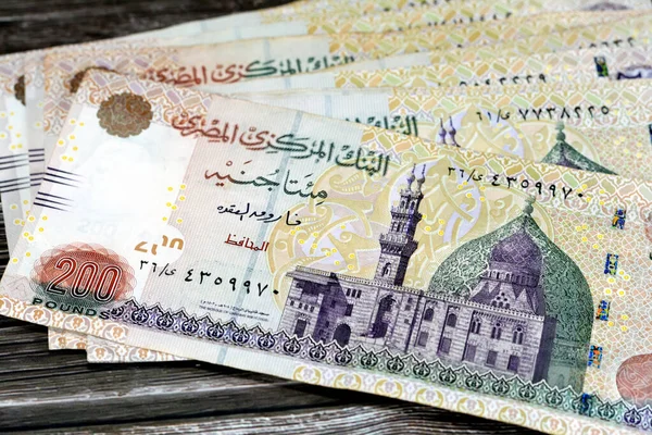 埃及开罗卡尼湾清真寺有200埃及镑钞票正面的一堆钞票 埃及中央银行选择性地将埃及现金钞票放在木头上隔离 — 图库照片