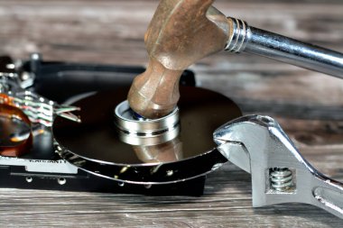 İngiliz anahtarı ve HDD plakalı çelik çekiç, hard disk parçalanmış bileşenler, bilgisayar bakımı, kurtarma, veri silme, veri öldürücü yazılım konsepti, seçici odaklanma