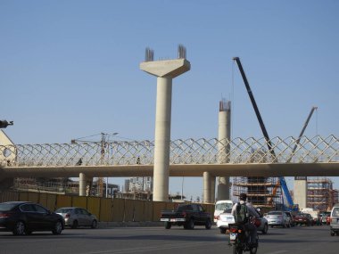 Giza, Mısır, 25 Temmuz 2022: Giza Mısır üstten taşıma sistemi demiryolu inşaat sahasında beton ve çelik kolonlar ve vinçler ile 6 Ekim 'de eksen yolunda