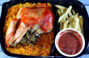 Uzun basmati pilavlı tavuk mandi ve patates kızartması, domates soslu, Yemen usulü, baharatlı ve soslu Mandi tavuğu tarifinin seçici odak noktası.