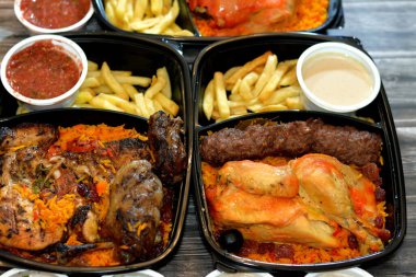 Geleneksel körfez yemekleri arka planında domates soslu Yemen tavuğu, ızgara tavuk, ızgara et, ızgara kofta, katran kebap, uzun Basmati pilavı, yeşil salata ve tahini.
