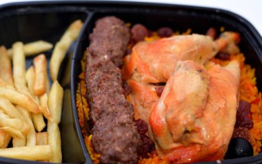 Uzun basmati pilavlı tavuk ve patates kızartması, ızgara et Kofta domates soslu, Yemen usulü Mandi tavuğunun seçici odaklı tarifi izole edilmiş.
