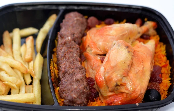 Uzun basmati pilavlı tavuk ve patates kızartması, ızgara et Kofta domates soslu, Yemen usulü Mandi tavuğunun seçici odaklı tarifi izole edilmiş.