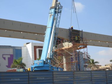 Kahire, Mısır, 14 Ekim 2022: Yeni Kahire raylı taşıma sisteminin inşaat sahası ağır mobil vinç ve işçilerin tamir ve montajı ile halen devam ediyor