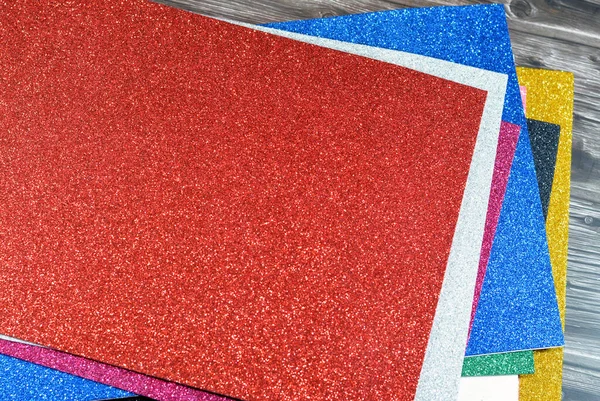 Glittered colorful Eva foam sheets, colored cardboard, rubber pad, sponge papers for school arts and crafts, pile of multicolored school board papers for children, back to school education concept