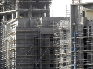 Yeni konut binaları ve vinçlerle dolu bir inşaat alanı, ağır nesneleri taşımak için, Mısır 'daki emlak projelerinde gündüz vakti inşaat binalarının altında seçici bir odak noktası